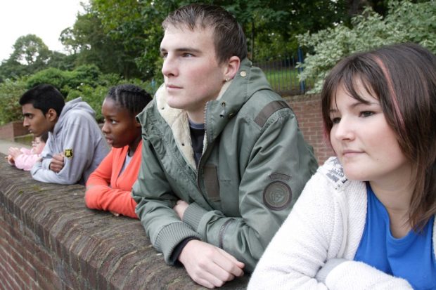 Teenagers leaning against a wall