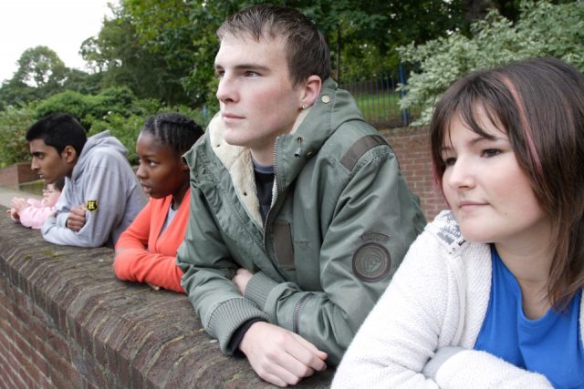 Teenagers lining up against a wall