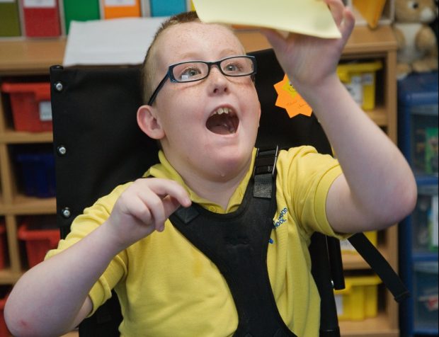 Boy with Cerebral Palsy celebrating success in a lesson,