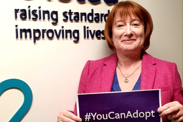 Yvette stanley holding a placard saying "you can adopt"