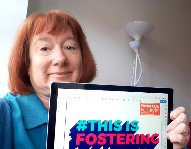 Picture of Yvette Stanley holding a sign to celebrate Foster Care Fortnight