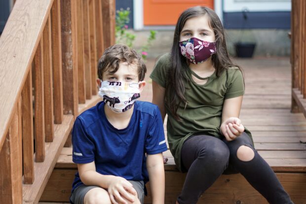 Two young children wearing COVID masks