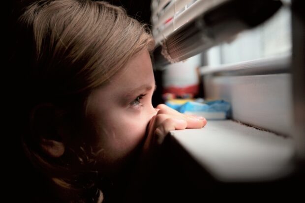 Close up of girl looking out of a window