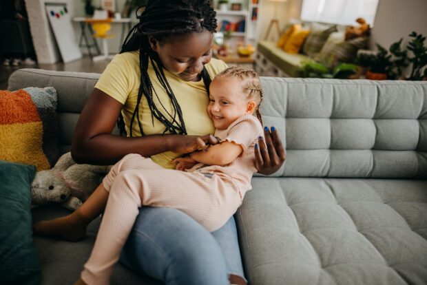 Foster carer and child sat on sofa together.