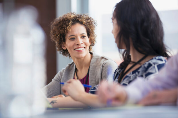 Adult women having a conversation in classroom.